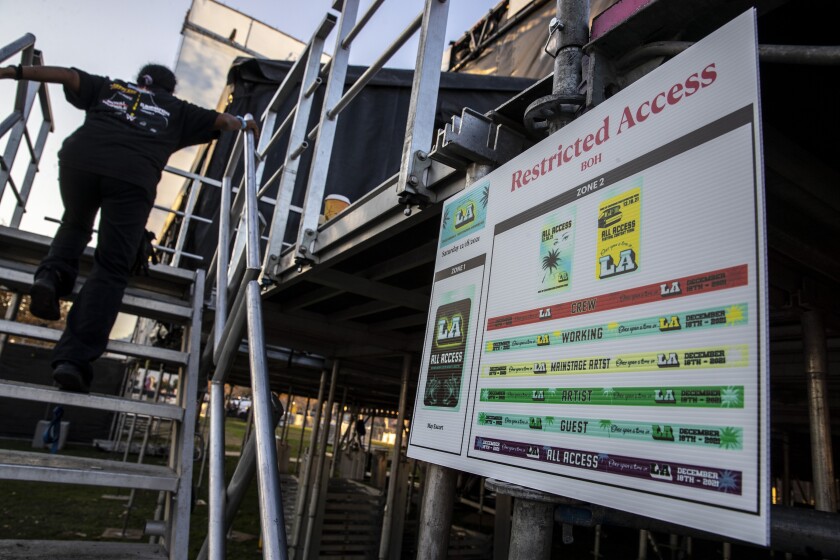 A worker climbs a stairway in a backstage area. 