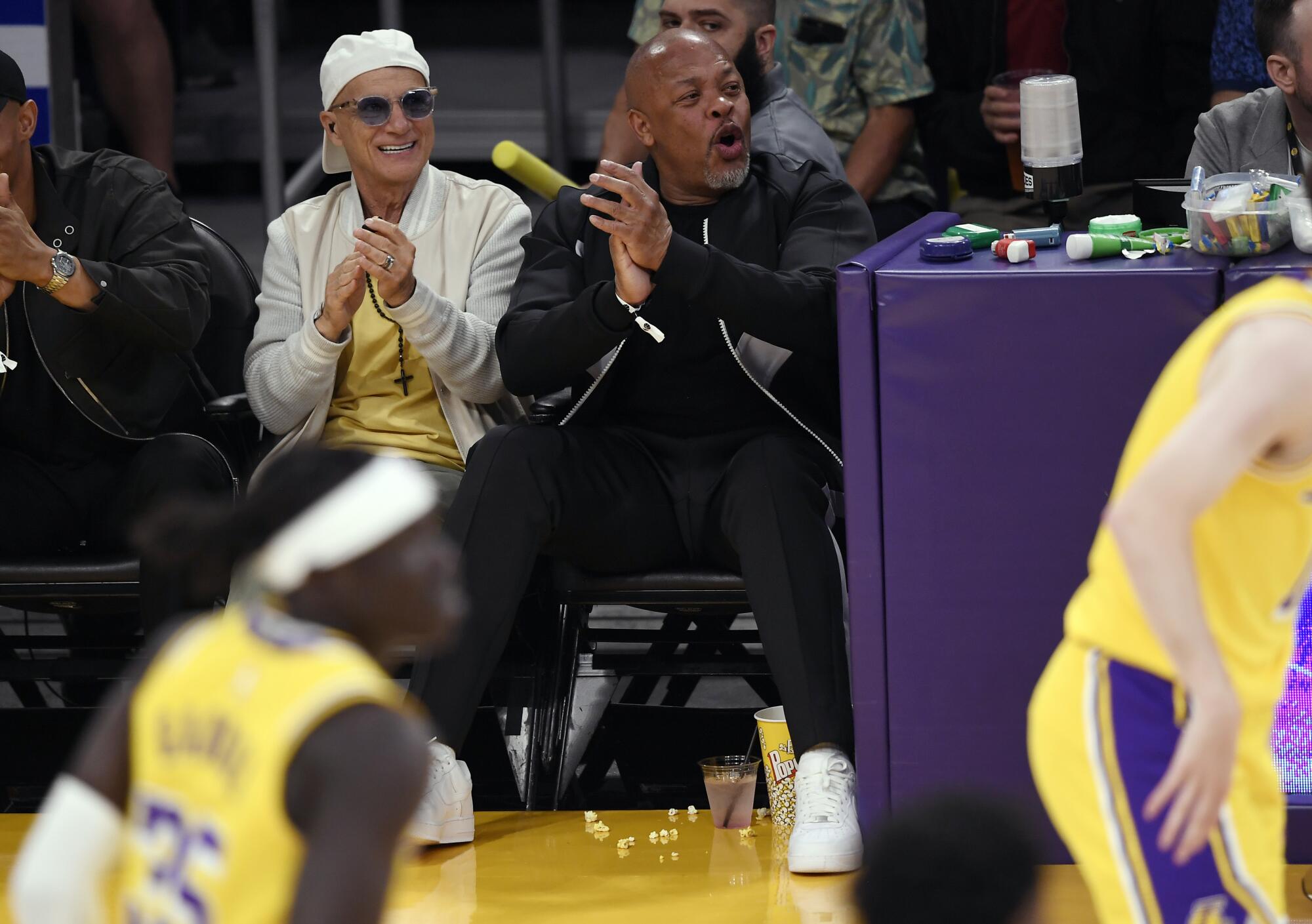 Dr. Dre and Jimmy Iovine attend a basketball game.