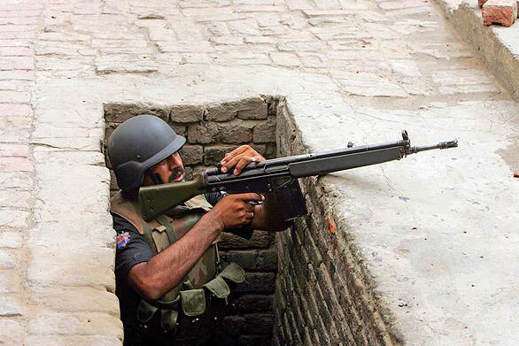 A Pakistani paramilitary soldier takes a position near a mosque in Lahore's Garhi Shahu neighborhood after the building was stormed by suspected militants. Attacks on two mosques of the minority sect known as the Ahmadis killed at least 52 people.