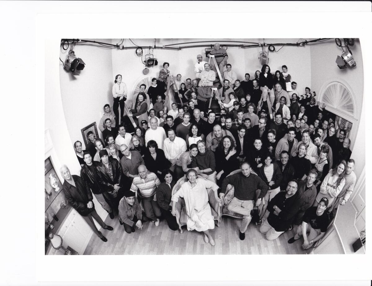 A black and white image of a large group of people seated looking upward.