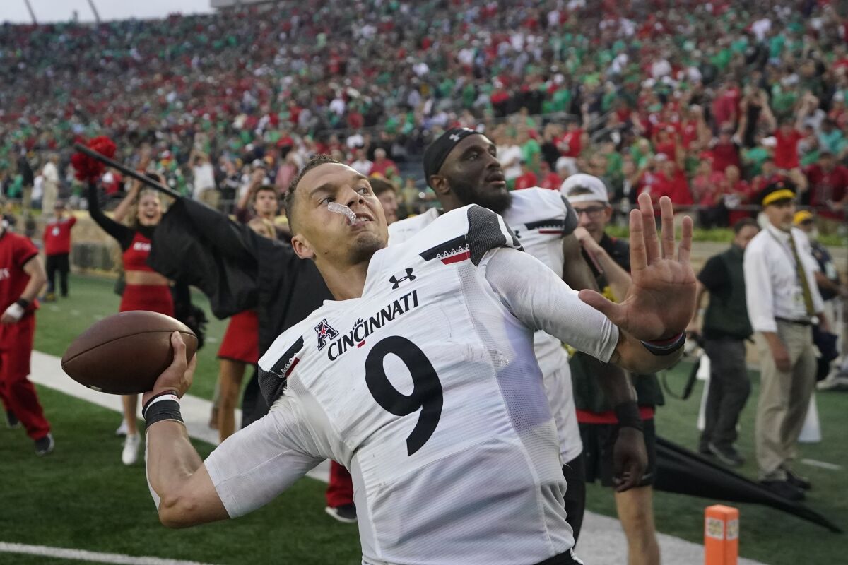 Cincinnati quarterback Desmond Ridder (9) throws a football into the stands after Cincinnati defeated Notre Dame, 24-13, in an NCAA college football game, Saturday, Oct. 2, 2021, in South Bend, Ind. (AP Photo/Darron Cummings)