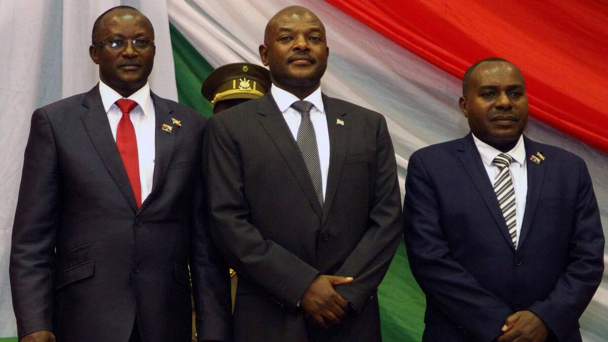 Burundi's President Pierre Nkurunziza, center, with his new first and second vice presidents Gaston Sindimwo and Joseph Mutore, after being sworn in for a controversial third term. In a speech afterward he swore his opponents would be crushed by God. (Landry Nshimiye / AFP/Getty Images)