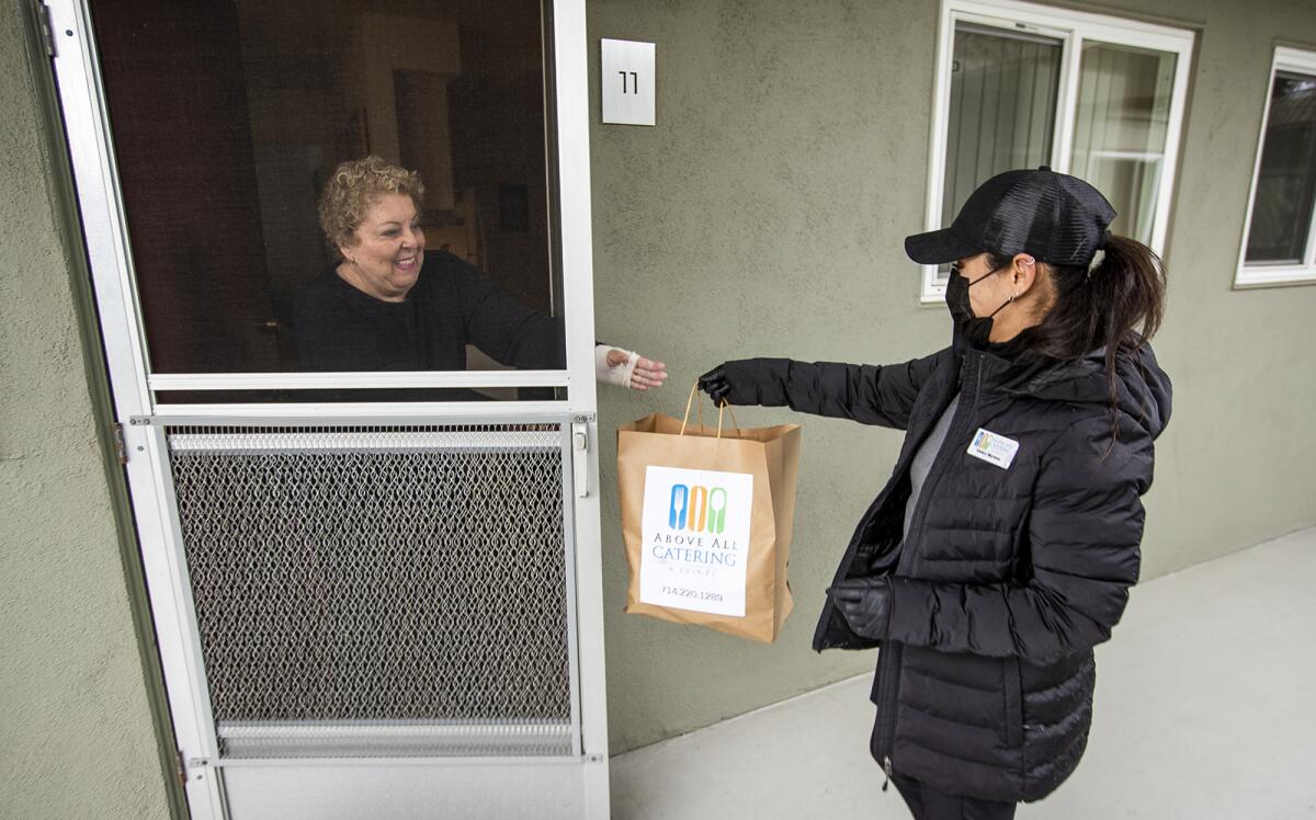 Valery Moreno delivers meals for Meals on Wheels Orange County to Lillian Modzeleski on March 3.