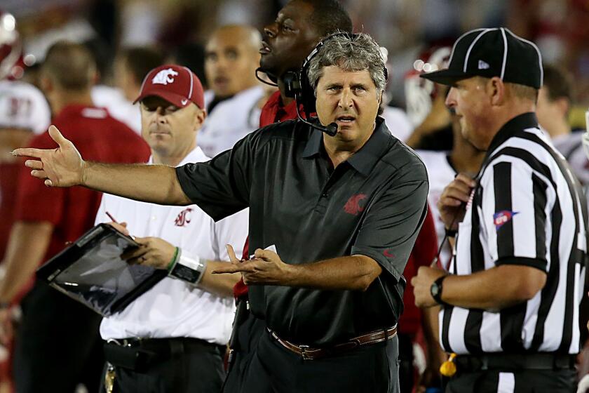 Washington State Coach Mike Leach talks with an official in the fourth quarter of a game against USC on Sept. 7, 2013.
