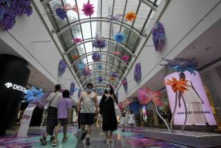 Residents wearing face masks walk through the reopening shopping mall decorated with colorful flowers after being closed due to COVID-19 restrictions in Beijing, Sunday, May 29, 2022. (AP Photo/Andy Wong)