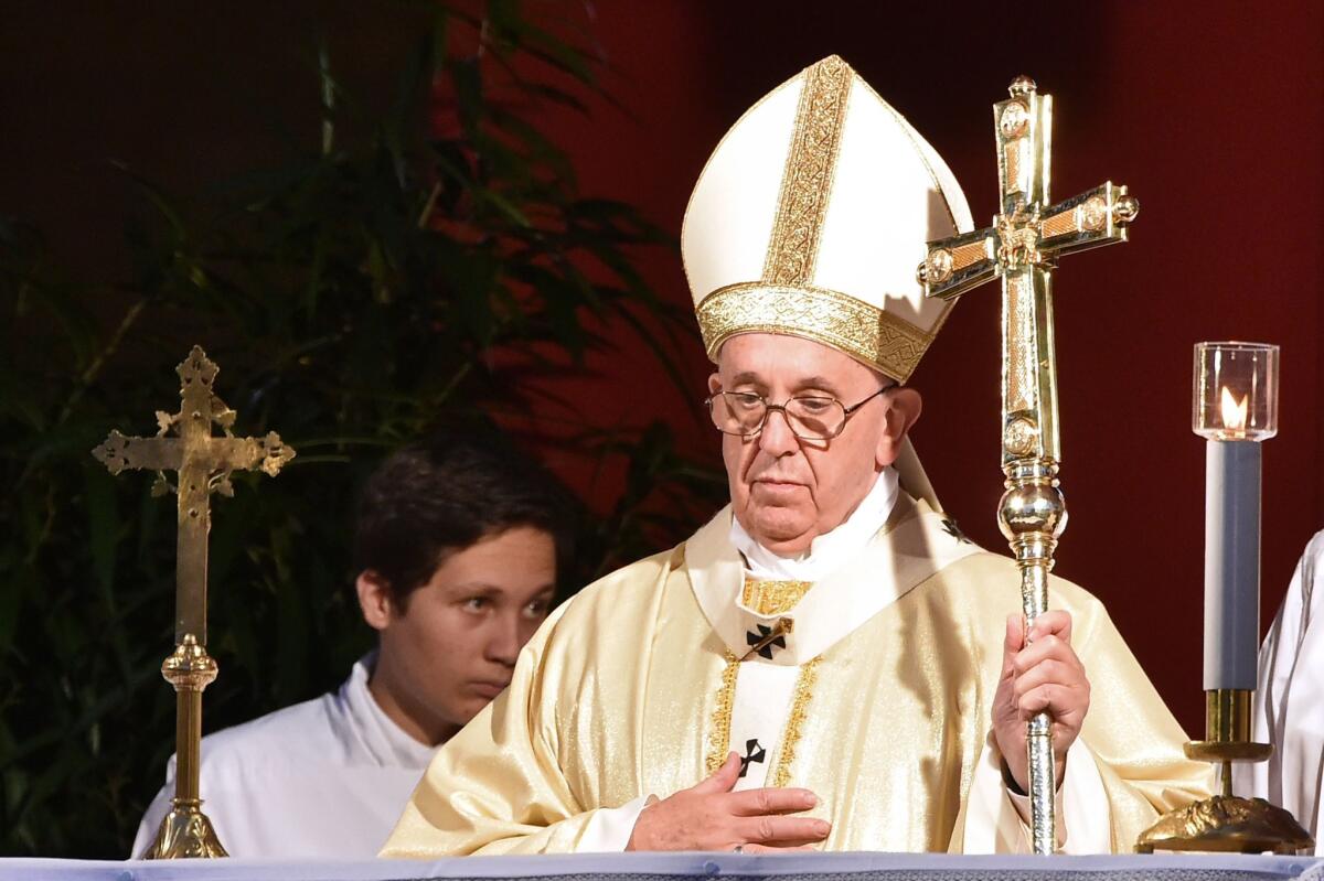 Pope Francis celebrates a Mass on Sunday for All Saints' Day at Campo di Verano cemetery in Rome. The Holy See revealed the following day that two people had been arrested in a probe of leaked Vatican confidential documents.