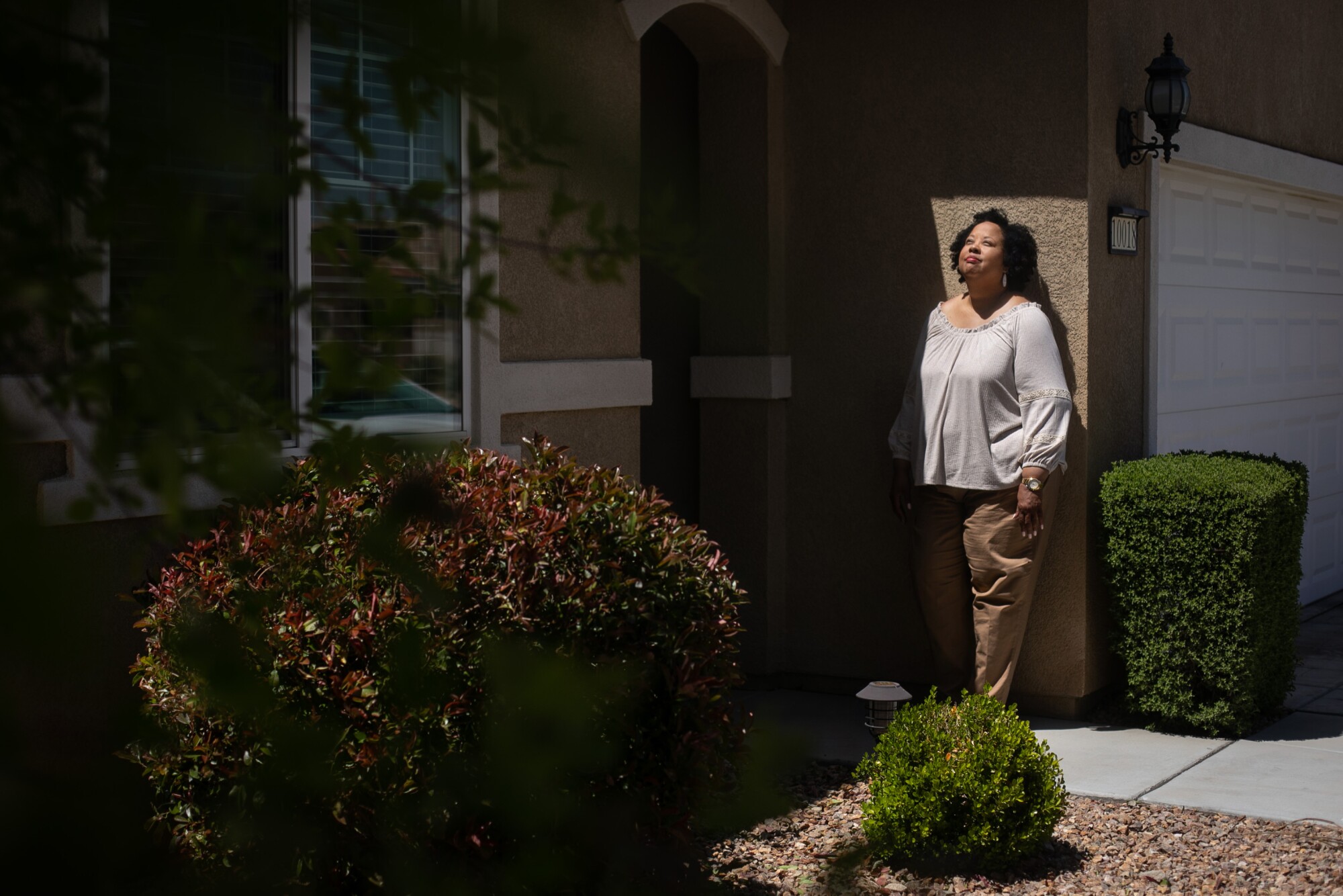 A woman stands outside her home in Apple Valley, California.