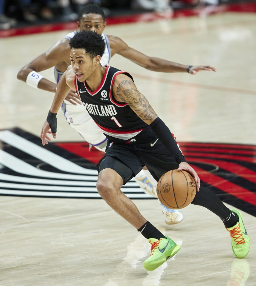 Portland Trail Blazers guard Anfernee Simons (1) drives to the basket in front of Sacramento Kings guard De'Aaron Fox during the second half of an NBA basketball game in Portland, Ore., Sunday, Jan. 9, 2022. (AP Photo/Craig Mitchelldyer)