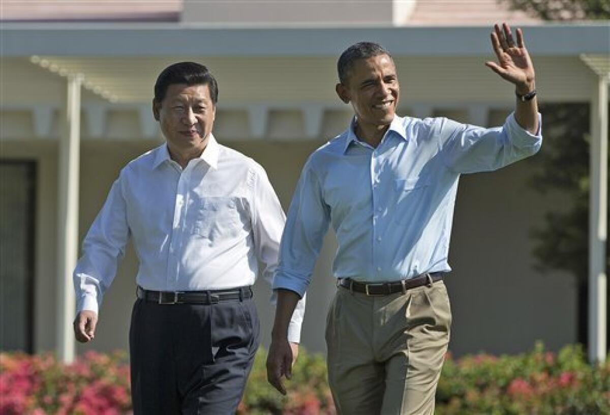 President Barack Obama, right, walks with Chinese President Xi Jinping at the Annenberg Retreat of the Sunnylands estate Saturday, June 8, 2013, in Rancho Mirage, Calif. During their walk President Obama told reporters his meetings with President Xi have been "terrific." The issue of cyber espionage hangs over the summit, although both leaders carefully avoided accusing each other of the practice. (AP Photo/Evan Vucci)