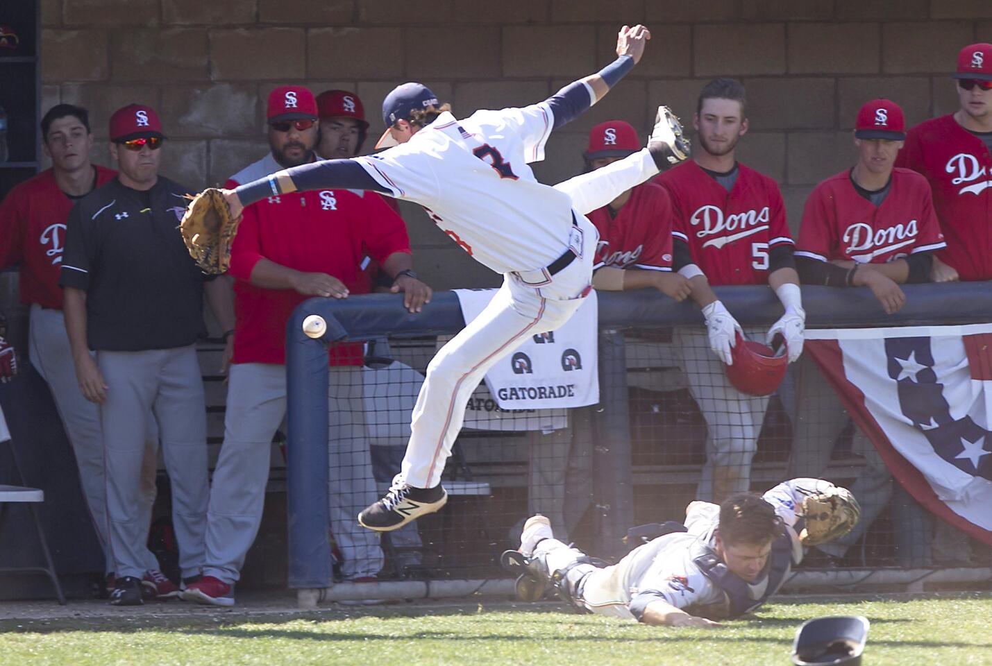 OCC third baseman Nolan Powers leaps over catcher Robert Teel as they go after a fly ball against Santa Ana in the second round of the Southern California Regional playoffs on Friday.