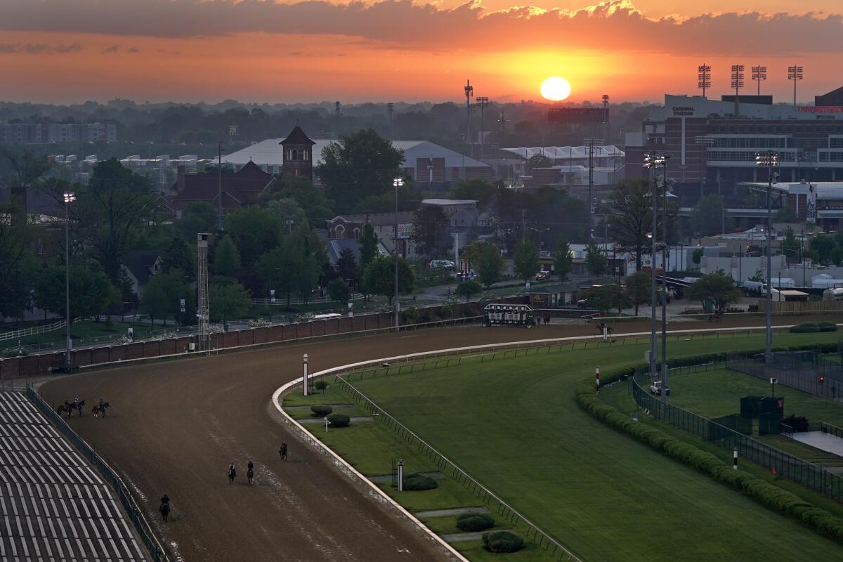 Horses work out as the sun rises at Churchill Downs on Friday.