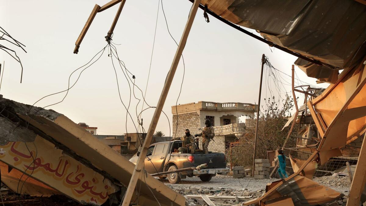 Iraqi soldiers drive through the town of Qayyarah, heavily damaged in August and again this past week, as Islamic State was driven out of town.