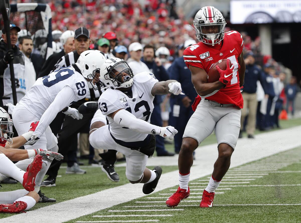 Ohio State receiver K.J. Hill Jr. makes a catch past Penn State linebacker Ellis Brooks (13) during the first quarter  Saturday.