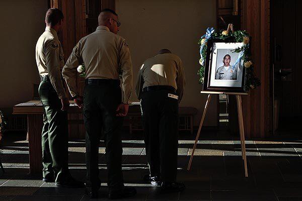 Los Angeles County Sheriff's Department Explorers write in a condolence book at the funeral Friday for fellow Explorer Cesar Rodriguez, 19, who was killed in a drive-by shooting about 3:30 a.m. Sunday while standing with a friend in front of a house in the 11800 block of Painter Avenue in an unincorporated area near Whittier.