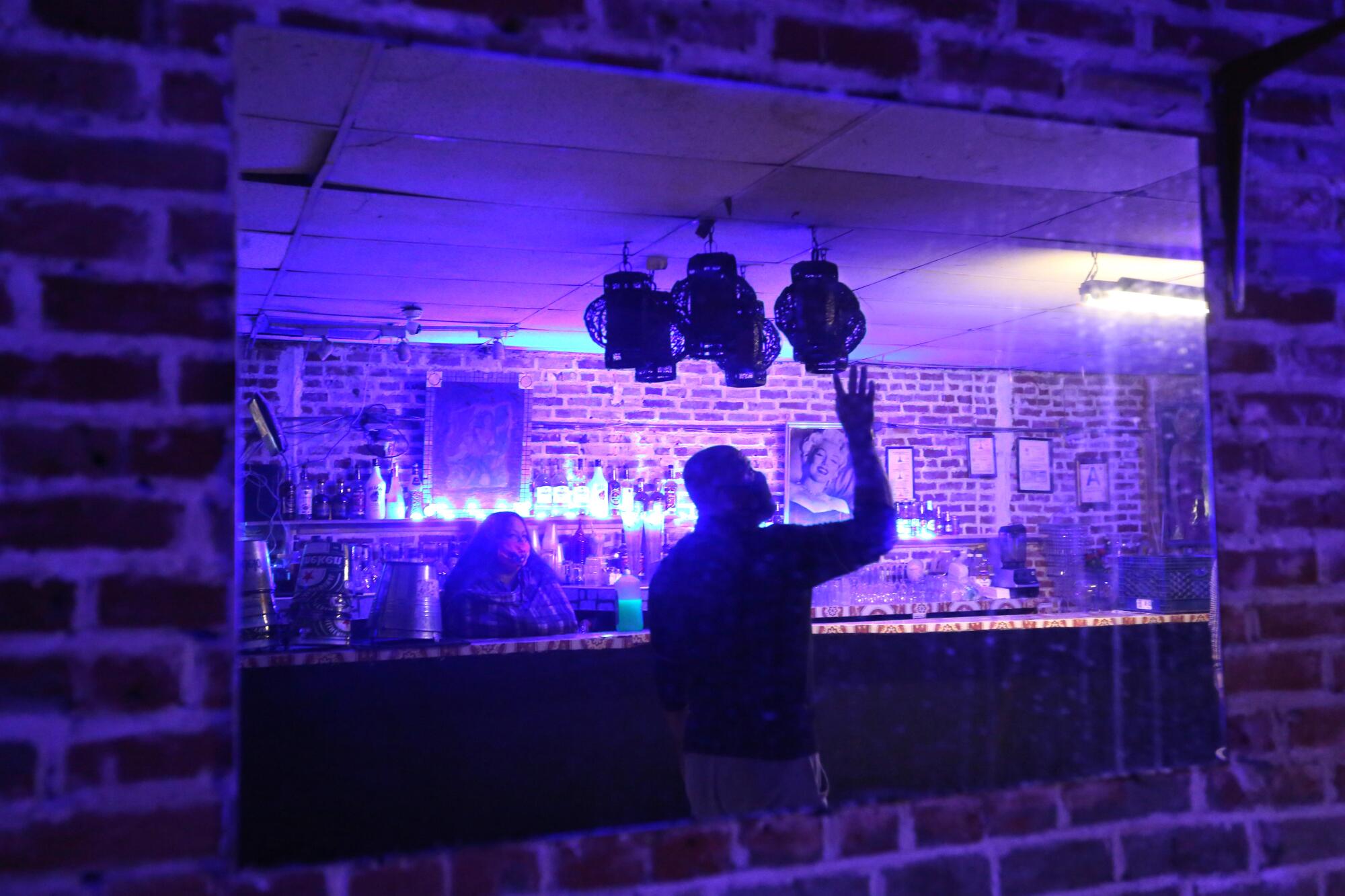 Sergio Hernandez checks a light inside the bar.