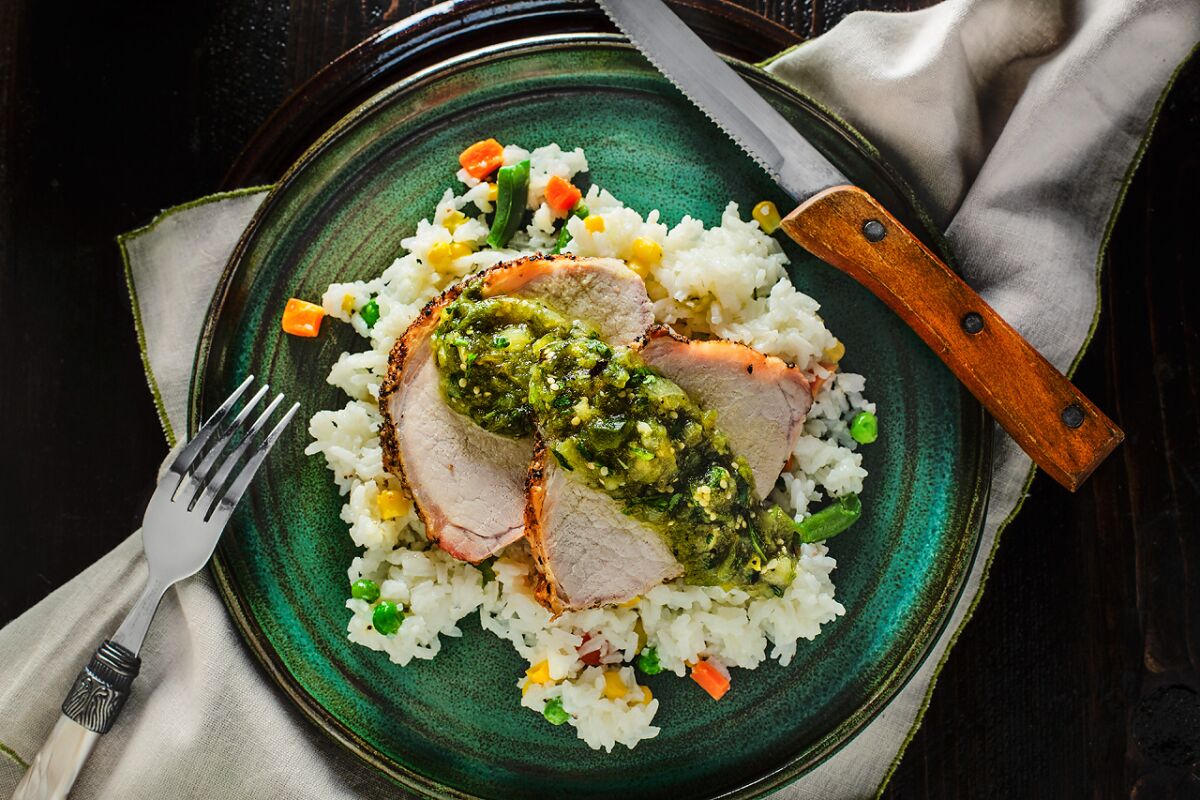 Easy-to-make pork loin with chunky salsa verde, served on a bed of rice with mixed vegetables. 
