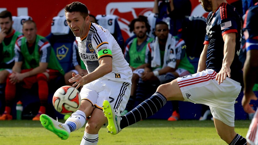 Galaxy forward Robbie Keane, left, takes a shot in front of New England's A.J. Soares during the MLS Cup final on Dec. 7, 2014.