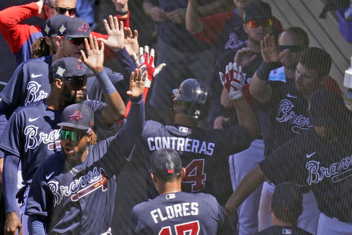 Atlanta Braves' William Contreras (24) is welcomed back to the dugout after a solo home run in the fifth inning during a spring training baseball game against the Toronto Blue Jays at CoolToday Park, Monday, March 28, 2022, in North Port, Fla. (AP Photo/Steve Helber)