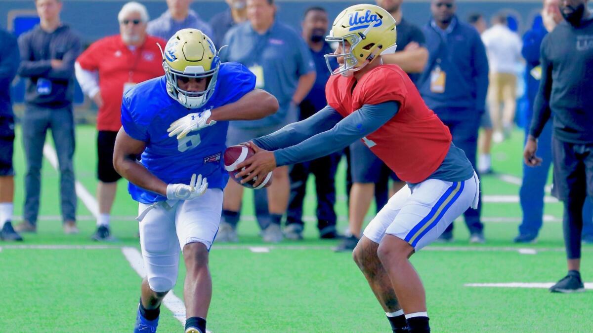 UCLA quarterback Dorian Thompson-Robinson fakes a hand-off to running back Martell Irby during a spring practice session.