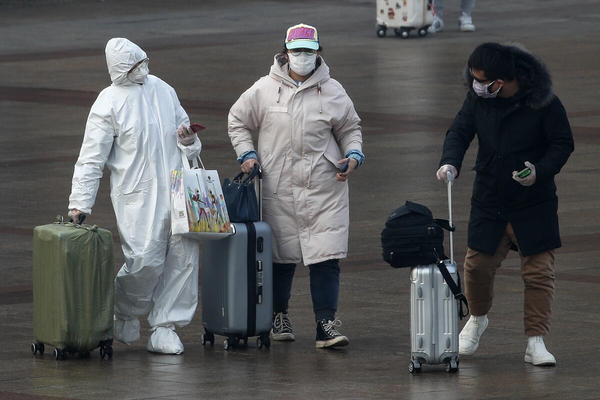 A passenger wearing a full-body protective suit at the Beijing railway station on Tuesday.