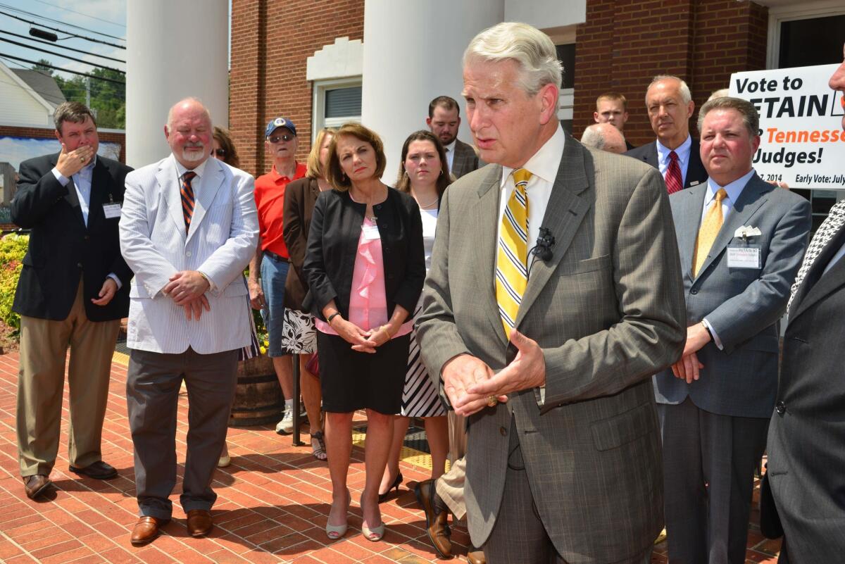 Backed by supporters, Tennessee Supreme Court Chief Justice Gary Wade gives a news conference about the retention of three Tennessee Supreme Court justices in Blountville, Tenn., on Tuesday.