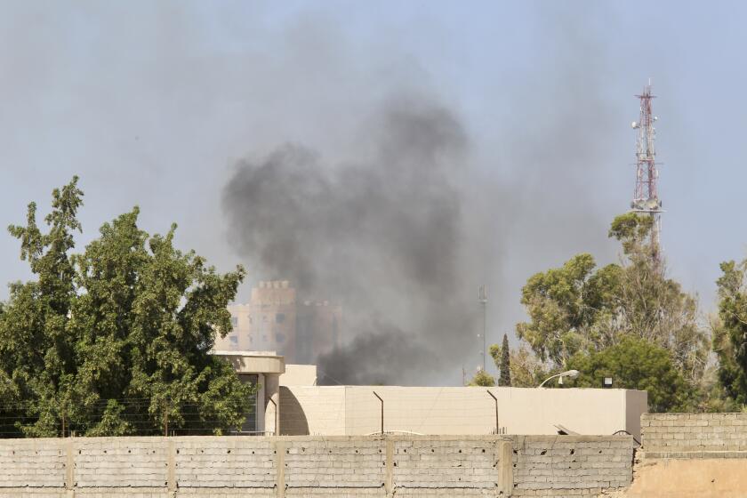 Smoke rises during clashes between rival militias in Tripoli, Libya, Tuesday, Aug. 15, 2023. According to local media, fighting broke out between the 444 brigade and the Special Deterrence Force late Monday evening. (AP Photo/Yousef Murad)