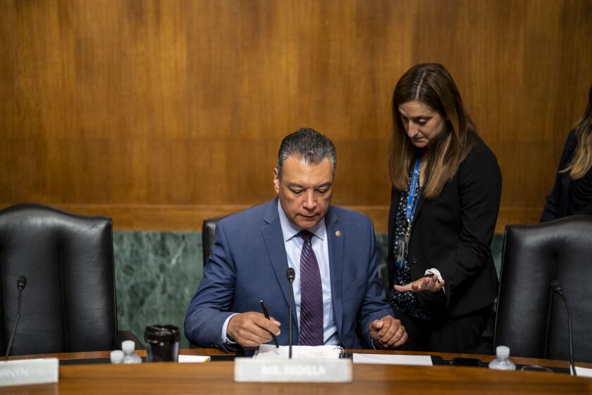 WASHINGTON, DC - JUNE 14: Sen. Alex Padilla (D-CA) with an aide prepares for a Senate Judiciary Subcommittee on Immigration, Citizenship and Border Safety hearing on Examining the Impact Immigration Policies Have on Access to Higher Education, on Capitol Hill on Tuesday, June 14, 2022 in Washington, DC. Ahead of the tenth anniversary of the Deferred Action for Childhood Arrivals (DACA) program, the hearing looks at challenges that students with DACA status, undocumented students, and international students face in seeking higher education and obtaining jobs in the United States following graduation. (Kent Nishimura / Los Angeles Times)