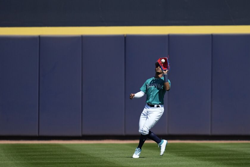 Seattle Mariners center fielder Julio Rodriguez catches a flyout off the bat of Colorado Rockies' Sean Bouchard during the first inning of a spring training baseball game Saturday, March 4, 2023, in Peoria, Ariz. (AP Photo/Abbie Parr)