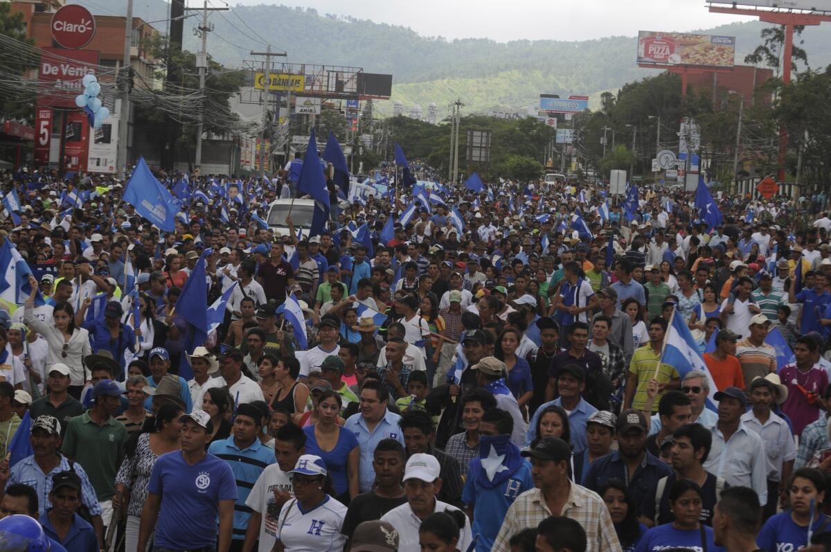 Miles de personas marchan en apoyo del presidente Juan Orlando Hernández en Tegucigalpa, Honduras, el domingo 28 de junio de 2015. Hernández ha estado bajo presión por un escándalo de corrupción que involucró la presunta malversación de hasta 120 millones de dólares del Instituto de Seguridad Social del país centroamericano. La primera dama hondureña Ana García admitió el miércoles 1 de julio de 2015 que compró una residencia en Estados Unidos, lo que ha generado más críticas al gobierno de Hernández. (Foto AP/Fernando Antonio)