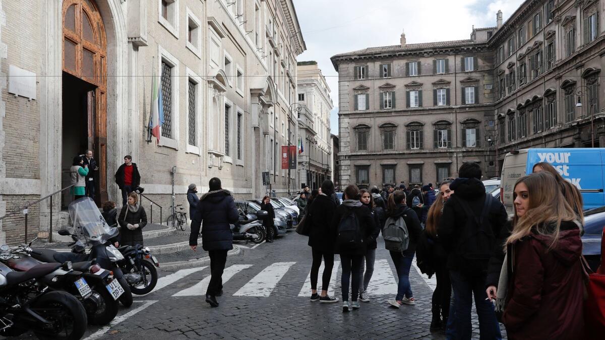 People stand outside an evacuated school after three earthquakes hit central Italy in the space of an hour in Rome on Wednesday, Jan. 18, 2017.