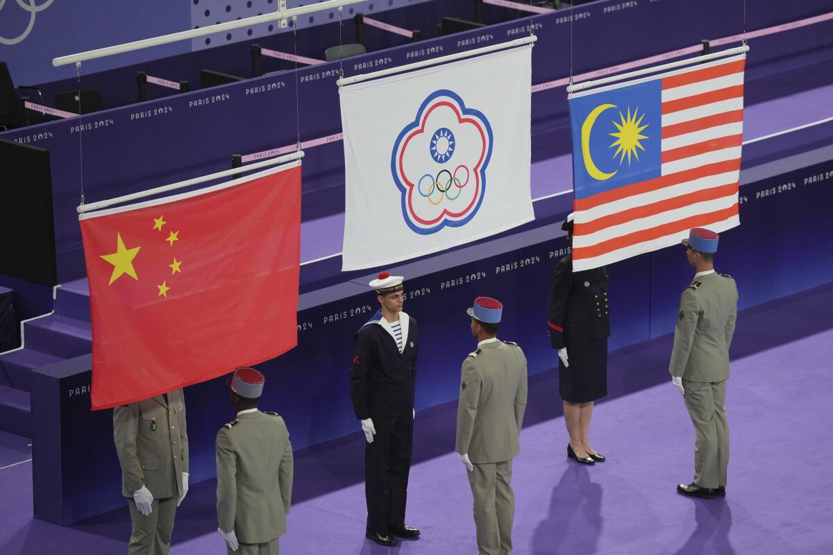 Chinese Taipei, China and Malaysia flags are raised during the medal ceremony for the men's doubles badminton.