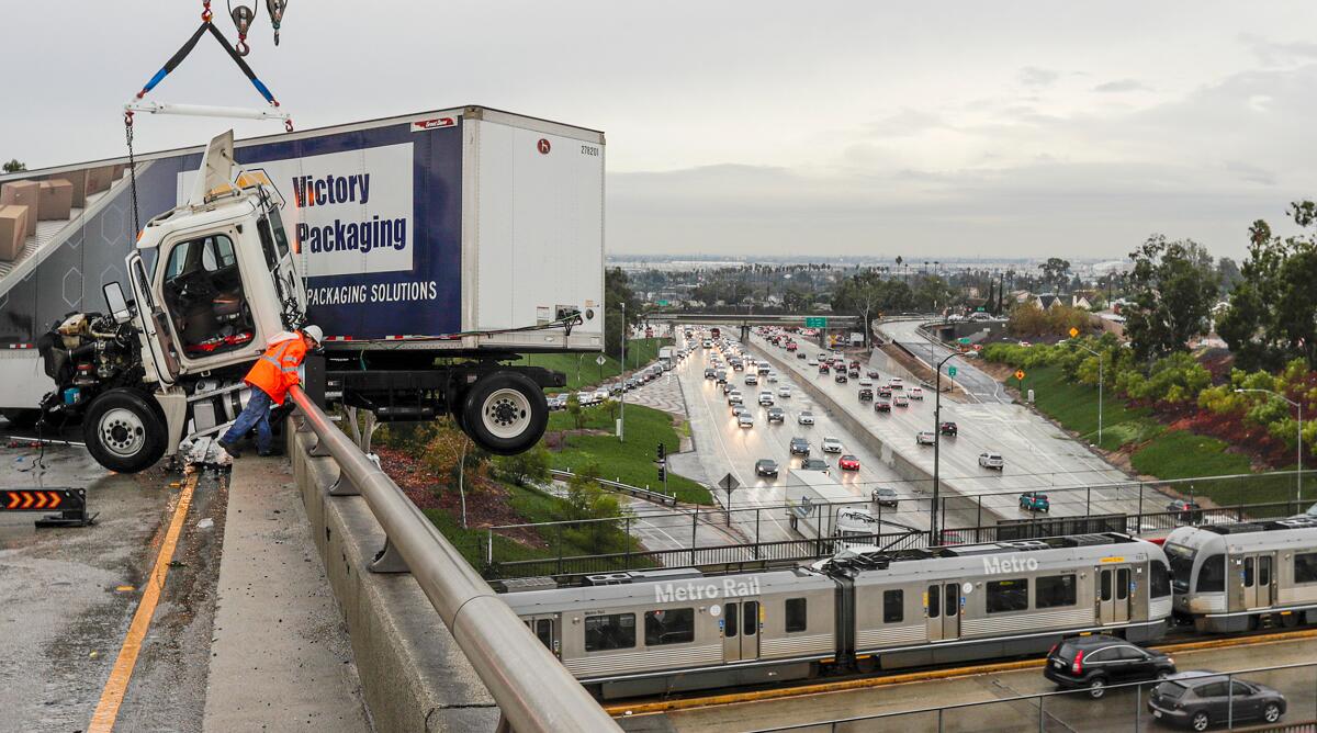 A big rig dangles over a ramp connecting the 710 and 60 freeways in Los Angeles amid steady rain early Wednesday. Heavy precipitation is expected to continue through the morning rush hour.