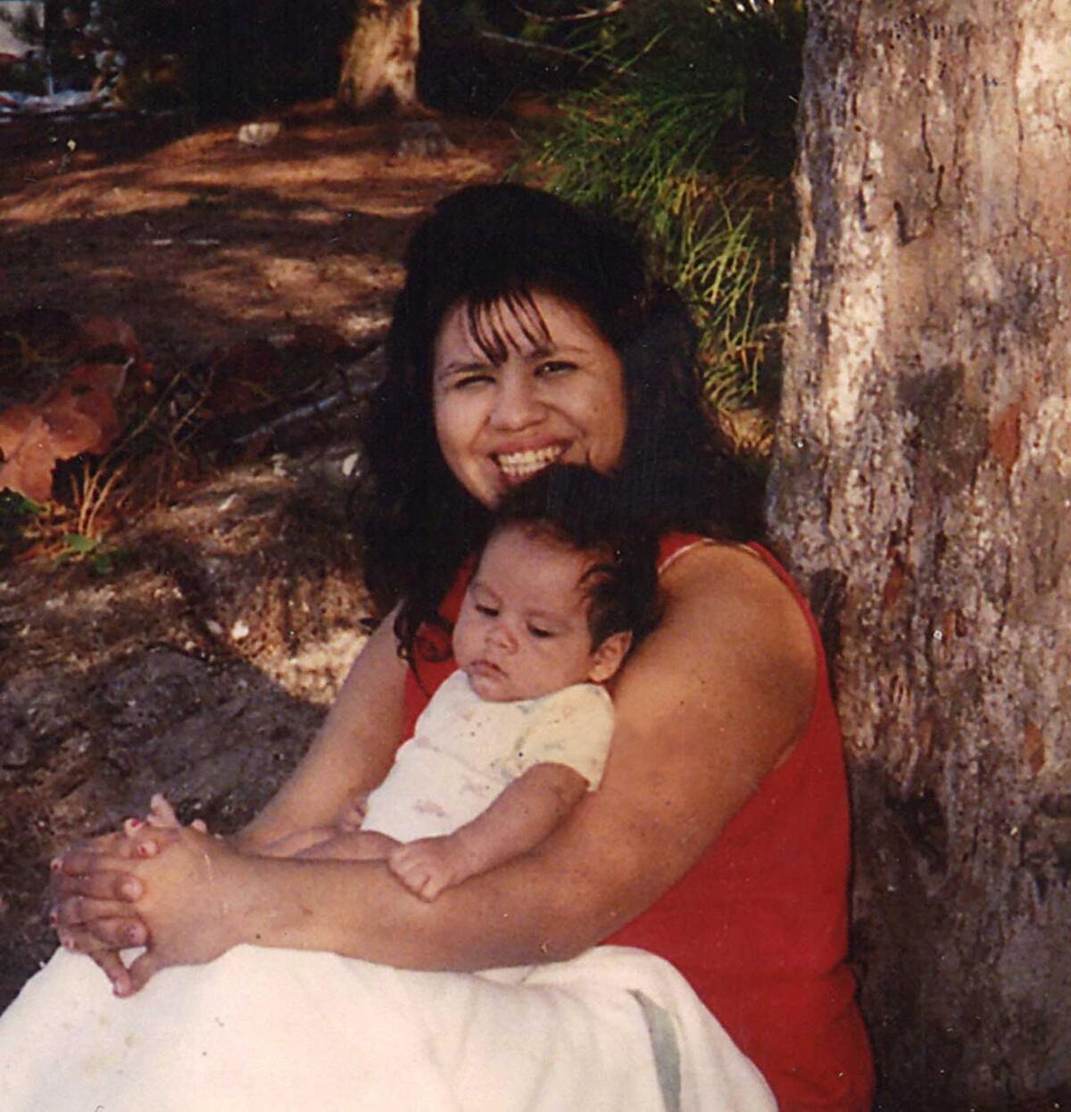 Melissa Lucio holds a small child and smiles