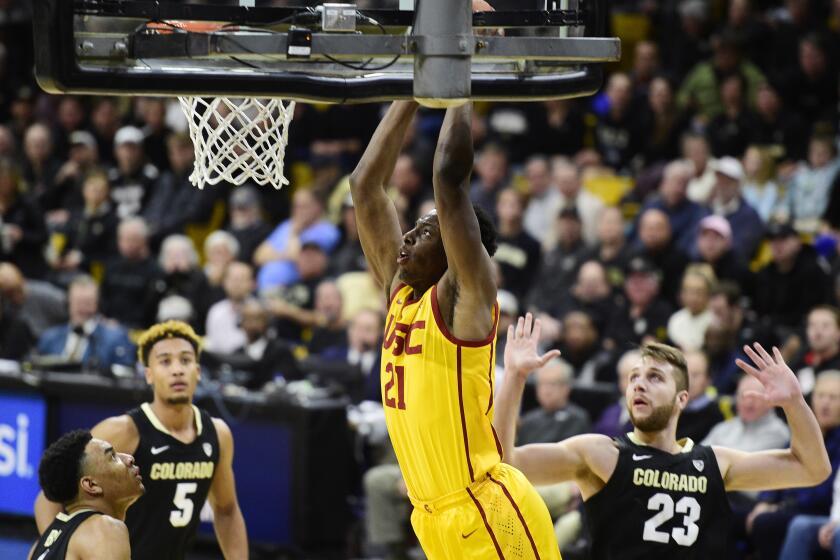 Colorado's Tyler Bey, left, D'Shawn Schwartz, and Lucas Siewert, look on as Southern California's Onyeka Okongwu dunks during the first half of an NCAA college basketball game Thursday, Feb. 20, 2020, in Boulder, Colo. (AP Photo/Cliff Grassmick)