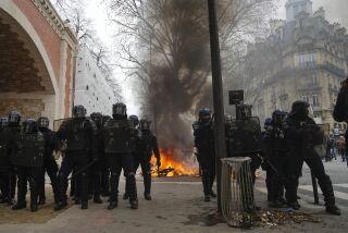 Policías están parados junto a una barricada en llamas durante una manifestación en París, el sábado 11 de marzo de 2023. (AP Foto/Lewis Joly )