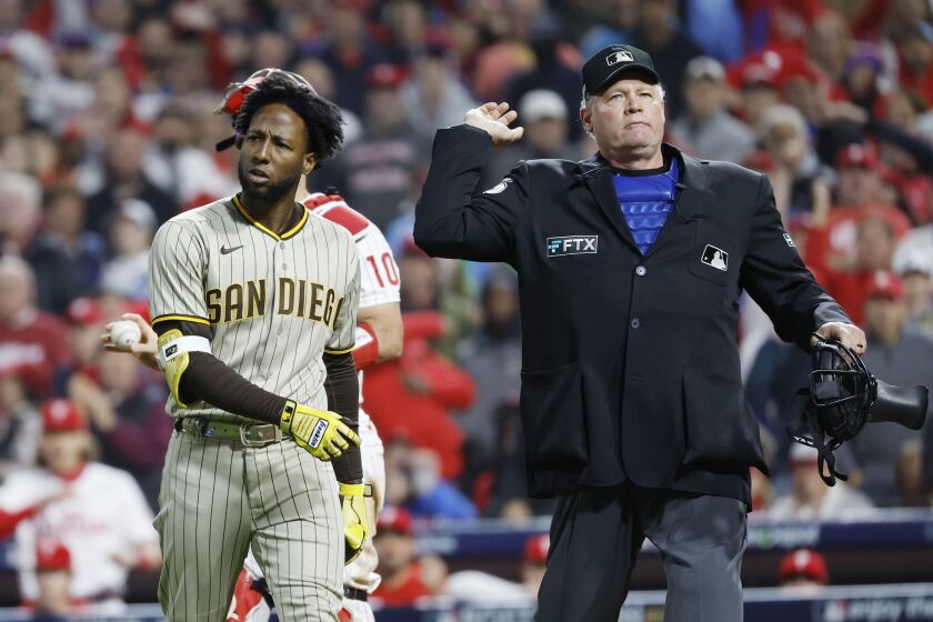 Philadelphia, PA - October 21: Jurickson Profar #10 of the San Diego Padres is ejected by umpire Ted Barrett as J.T. Realmuto #10 of the Philadelphia Phillies looks on during the ninth inning of Game 3 of Game 3 of the NLCS at Citizens Bank Park on Friday, Oct. 21, 2022 in Philadelphia, PA. (K.C Alfred/ The San Diego Union-Tribune)