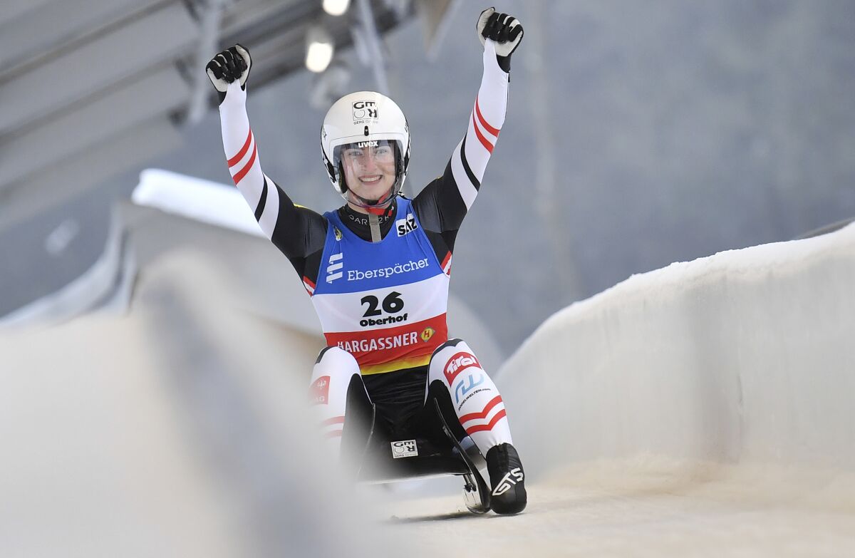 Madeleine Egle from Austria cheers at the finish line in the women's singles event of the Luge World Cup in Oberhof, Germany, Sunday, Jan. 16, 2022. Egle wins the competition ahead of Taubitz and Berreiter. (Martin Schutt/dpa via AP)