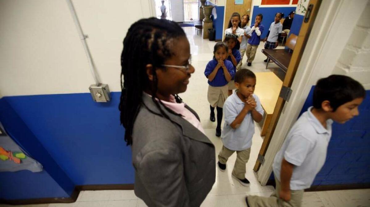 Celerity Educational Group founder Vielka McFarlane watches students walk to class at Celerity Nascent Charter School in Los Angeles.