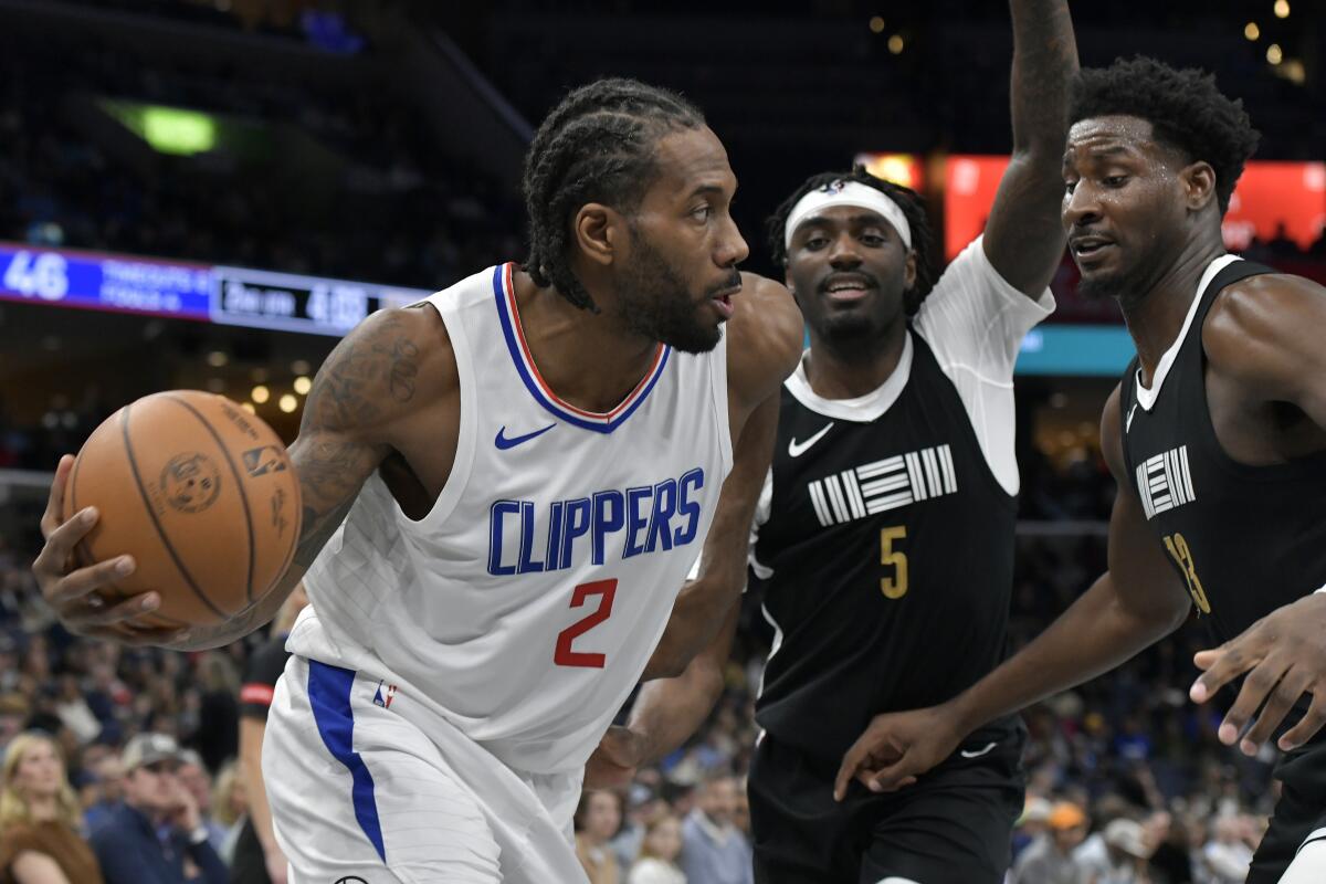 Clippers forward Kawhi Leonard controls the ball in front of Memphis guard Vince Williams Jr. and forward Jaren Jackson Jr. 