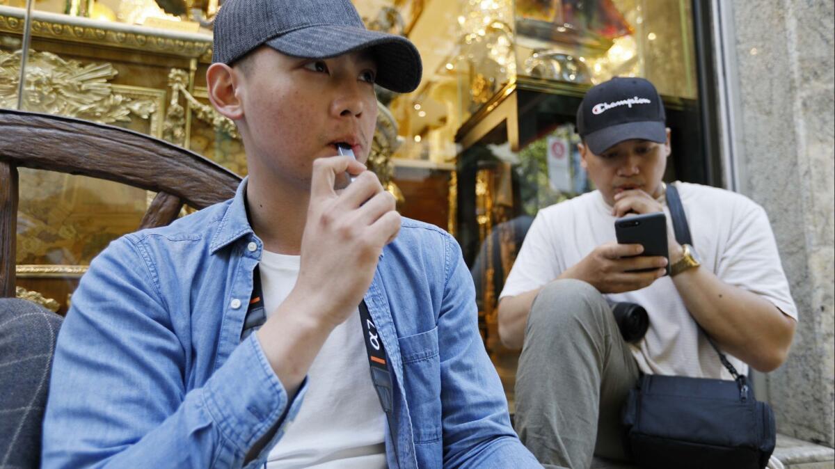 Joshua Ni, 24, and Fritz Ramirez, 23, vape from electronic cigarettes in San Francisco.