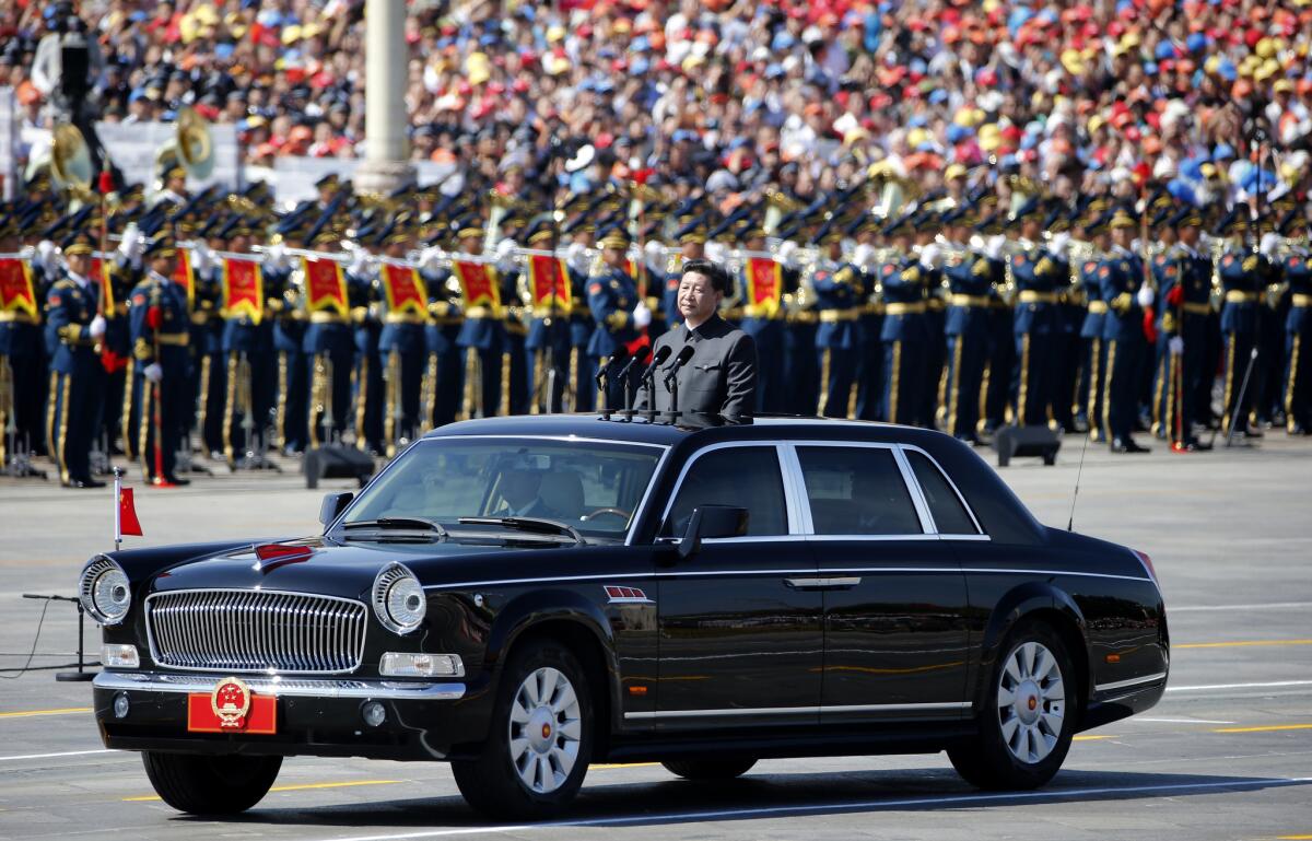 Chinese President Xi Jinping stands in a car to review the army during a parade commemorating the 70th anniversary of Japan's surrender during World War II, held in front of Tiananmen Gate in Beijing on Sept. 3.