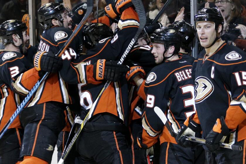 Ducks players celebrate teammate Cam Fowler's overtime goal in a 2-1 win over the Vancouver Canucks on Sunday.