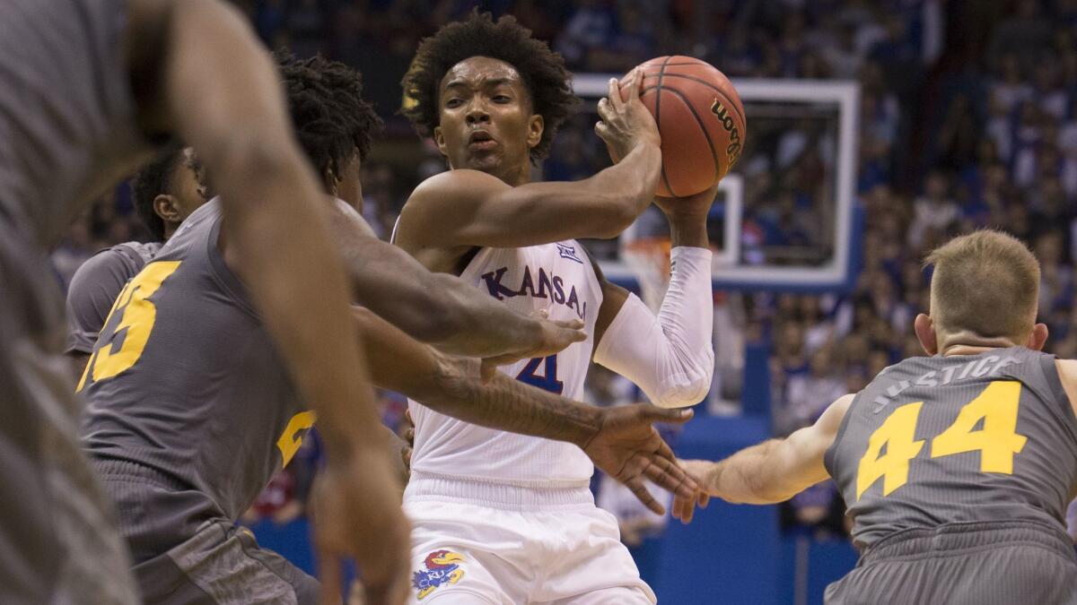 Devonte' Graham of the Kansas Jayhawks gets cut off by the Arizona State Sun Devils defense during the game at Allen Fieldhouse.