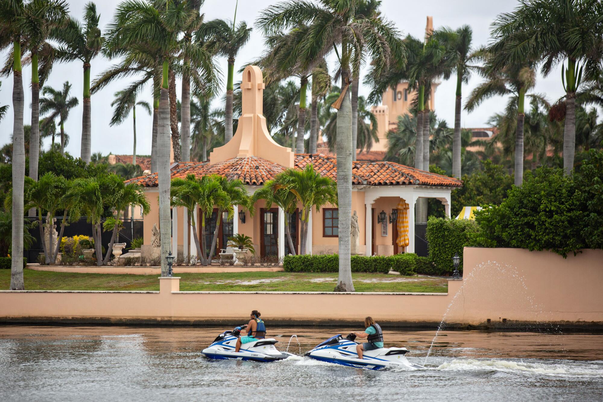 People on Jet Skis pass Mar-a-Lago in Palm Beach.