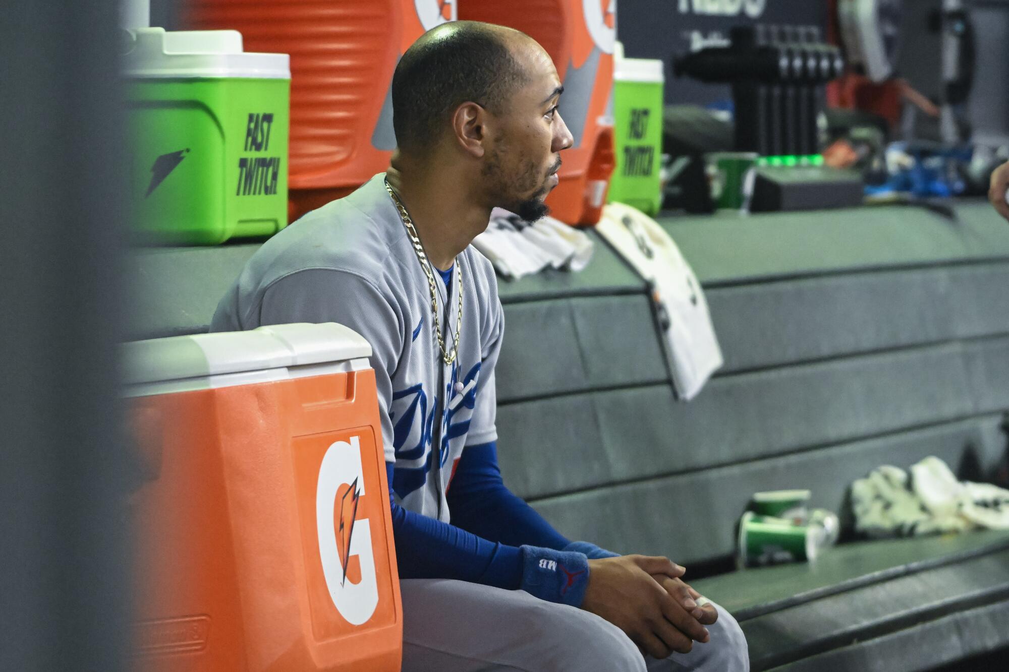 Mookie Betts sits in the dugout during the Dodgers' Game 3 loss to the Arizona Diamondbacks on Wednesday. 