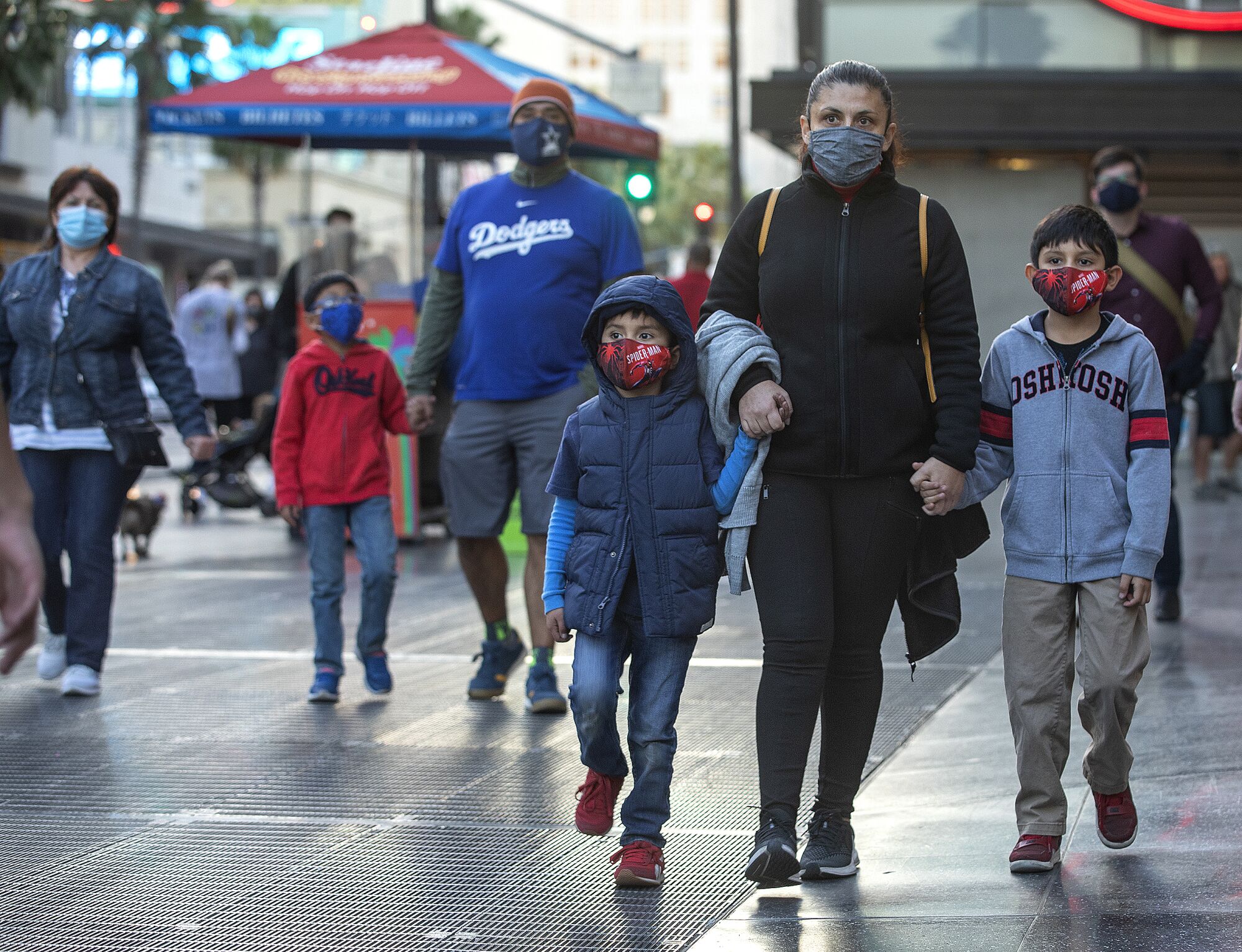 A family wears protective masks during a walk in Hollywood.