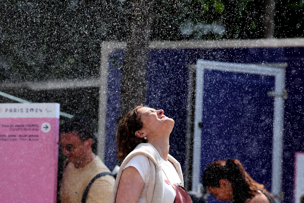 A spectator attending the Olympic tennis tournament at Roland Garros in Paris on Wednesday tries to stay cool.