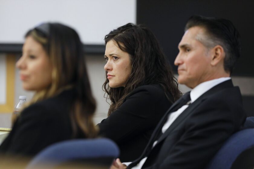 Vista, CA - December 07: Jade Janks listens to the opening statement of prosecutor Jorge Del Portillo on the first day of her murder trial at the Vista Courthouse. With her is her legal team, lawyers Marc Carlos and Michelle Camacho. (Charlie Neuman / For The San Diego Union-Tribune)
