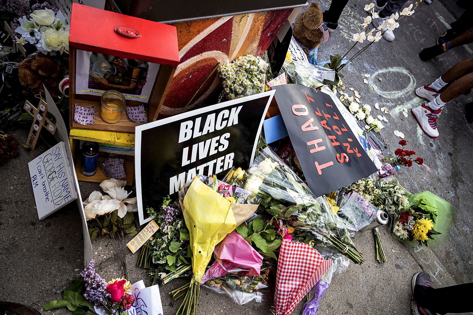 Flowers and "Black Lives Matter" signs are left at the site of Floyd's arrest.