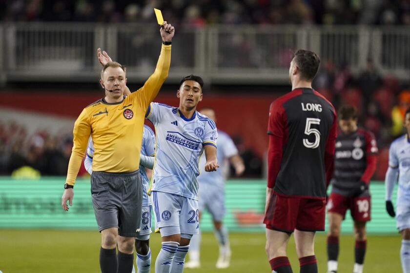 El árbitro Scott Bowman le muestra la tarjeta amarilla al defensa de Toronto Kevin Long mientras observa el delantero del Atlanta United Tyler Wolff el sábado 23 de marzo del 2024.(Arlyn McAdorey/The Canadian Press via AP)